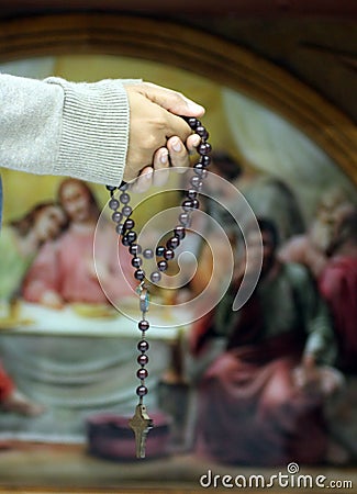 Praying hands with rosary on background of the last supper of Jesus. Holy week. Holy white Thursday concept Stock Photo