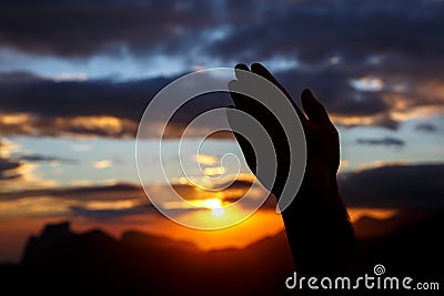 Praying hands on sunset background Stock Photo