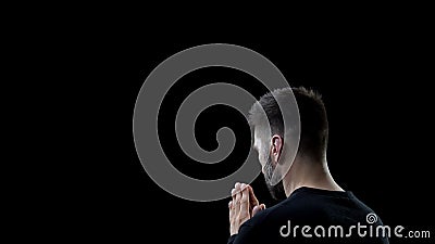 Praying man on black background, sins forgiveness, spiritual inspiration, help Stock Photo