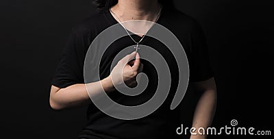 Praying with a rosary. hand of Catholic man with rosary on black background Stock Photo