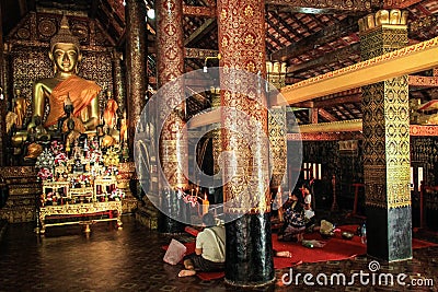 Praying at the Wat Mai Suwannaphumaham temple in Luang Prabang, laos Editorial Stock Photo