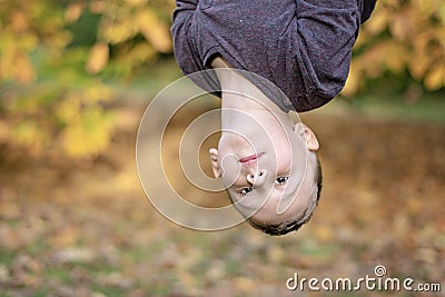 Pre-school age boy upside down outdoors Stock Photo