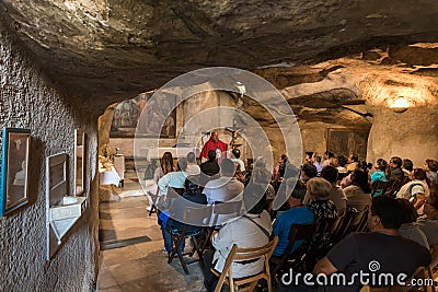 A preacher gives a sermon to visitors in the hall of the Grotto of Gethsemane on foot of the mountain Mount Eleon - Mount of Editorial Stock Photo