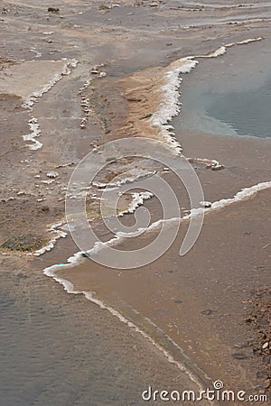 Precipitated salt forms a snowy outline of thermal pools Stock Photo