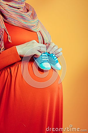 pregnancy , anticipation , love , hands, stomach, belly, shoes , boots , shoes , madenets , devyats months Stock Photo