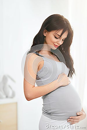 Pregnancy. Beautiful Smiling Pregnant Woman Stock Photo