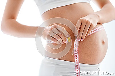 Pregnancy Body Measurements. Pregnant Woman Measuring Belly Stock Photo