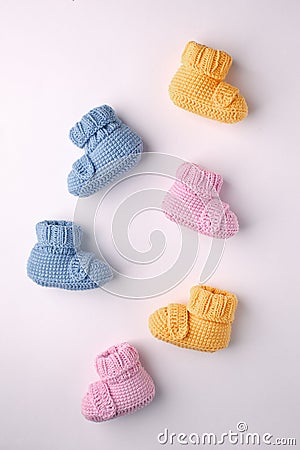 Pregnancy concept, Three pairs of baby booties on a light background, flat lay, pattern. Stock Photo