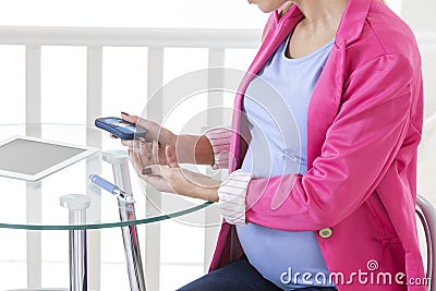 Pregnancy diabetes- Pregnant woman taking a blood sample glucose level Stock Photo