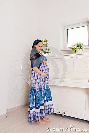 Pregnancy, motherhood, people and expectation concept - close up of happy pregnant woman with big belly indoors