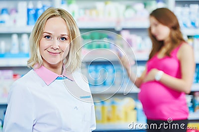 Pregnancy and pharmaceutics. pharmaceutist with pregnant on background at store Stock Photo