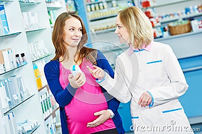 Pregnancy and pharmaceutics. pharmaceutist with pregnant at pharmacy store Stock Photo