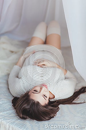 Pregnancy, rest, and expectation concept - close up of happy smiling pregnant woman lying in bed covered with canopy and Stock Photo