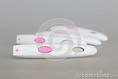 Pregnancy test close-up with a big pink button on a gray background Stock Photo