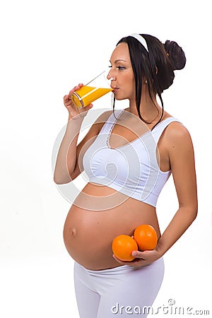 Pregnancy and vitamins. Pregnant woman and oranges and fresh juice. Stock Photo