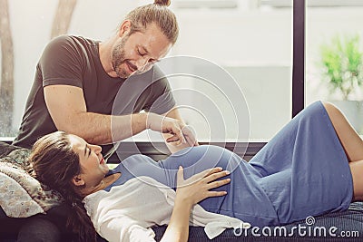Pregnancy wife stay home with lovely husband cute playing with baby tummy Stock Photo