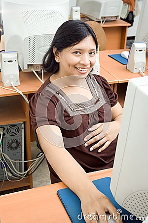 Pregnant asian woman working on computer Stock Photo