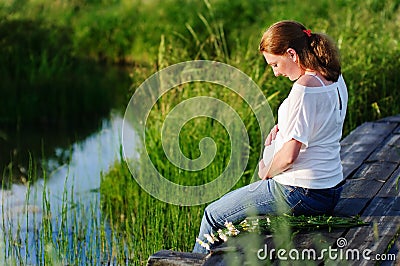 Pregnant beautiful woman with hands over tummy Stock Photo