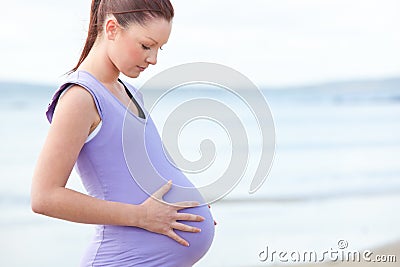 Pregnant beautiful woman watchning her stomach Stock Photo