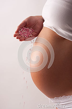 Pregnant belly with falling candy Stock Photo