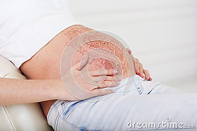 Pregnant belly with mehendi tattoo Stock Photo