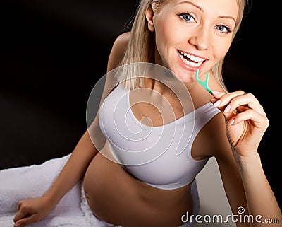 Pregnant blond woman checks her teeth Stock Photo