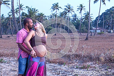 Pregnant couple walking on the beach Stock Photo