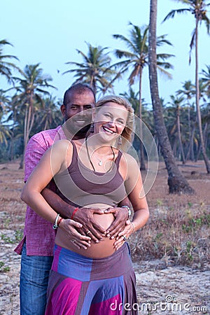 Pregnant couple walking on the beach Stock Photo