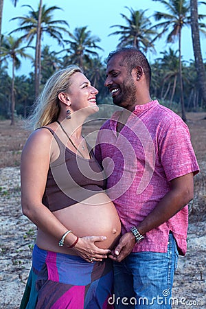 Pregnant couple walking on the beach Stock Photo