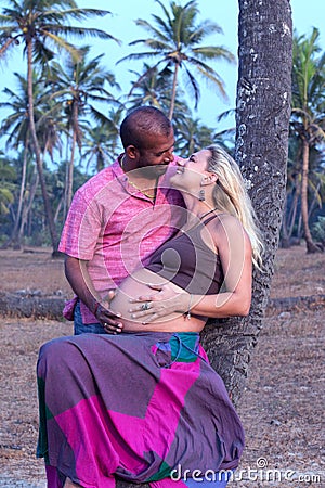 Pregnant couple walking on the beach Stock Photo