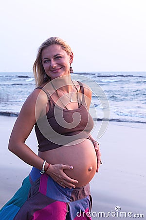 Pregnant couple walking on the beach Stock Photo