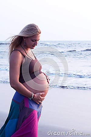 Pregnant couple walking on the beach Stock Photo