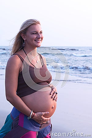 Pregnant couple walking on the beach Stock Photo