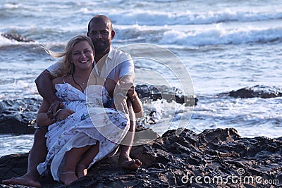 Pregnant couple walking on the beach Stock Photo