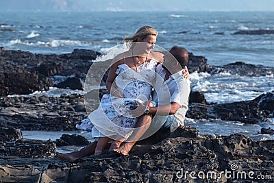 Pregnant couple walking on the beach Stock Photo