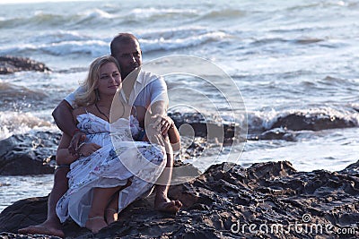 Pregnant couple walking on the beach Stock Photo