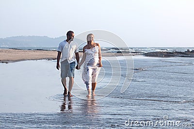 Pregnant couple walking on the beach Stock Photo