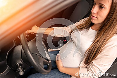 Pregnant driving car. Young smiling pregnancy woman driving car. Safety pregnant young mom driving concept. Stock Photo