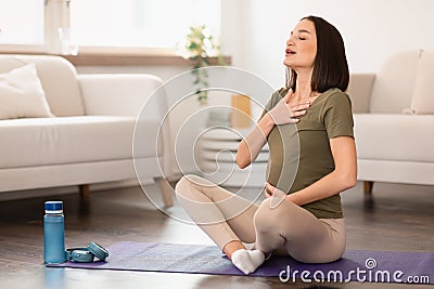 Pregnant european lady engages in meditation and breathing exercise indoor Stock Photo