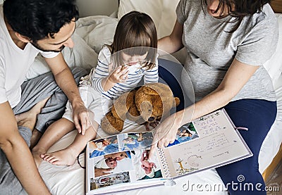 Pregnant family looking through a family photo album Stock Photo