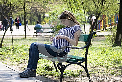 Pregnant girl on a bench Stock Photo