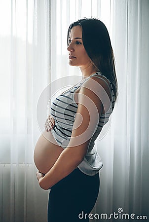 Pregnant holding her nacked belly Stock Photo