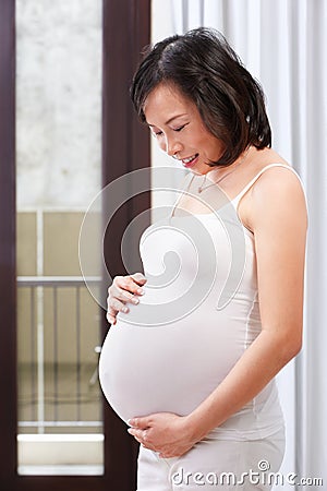 Pregnant lady caress her stomach Stock Photo