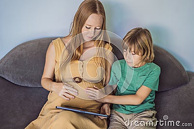 pregnant mom and son look at the tablet. Reading a book or watching a cartoon or making a video call. Look at the photo Stock Photo