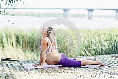 Pregnant practices yoga outdoors. Prenatal Yoga and Fitness Stock Photo