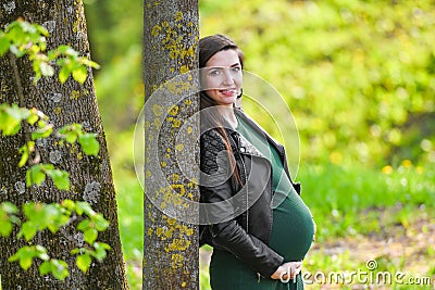 Pregnant schoolgirl. Attractive pregnant woman in dress schoolgirl posing on the street. Long-haired pregnant woman walking down Stock Photo