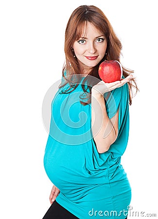 A pregnant smiling woman is holding an apple Stock Photo