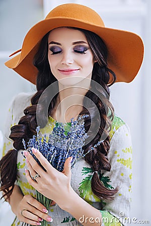 Pregnant stylish beautiful european woman with lavender bouquet in white flat, young european woman waiting for a child Stock Photo