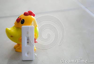 Pregnant test with a toy doll yellow chick Stock Photo