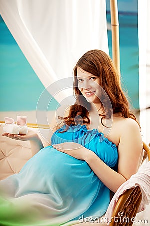 Pregnant woman on the beach in bungalow Stock Photo